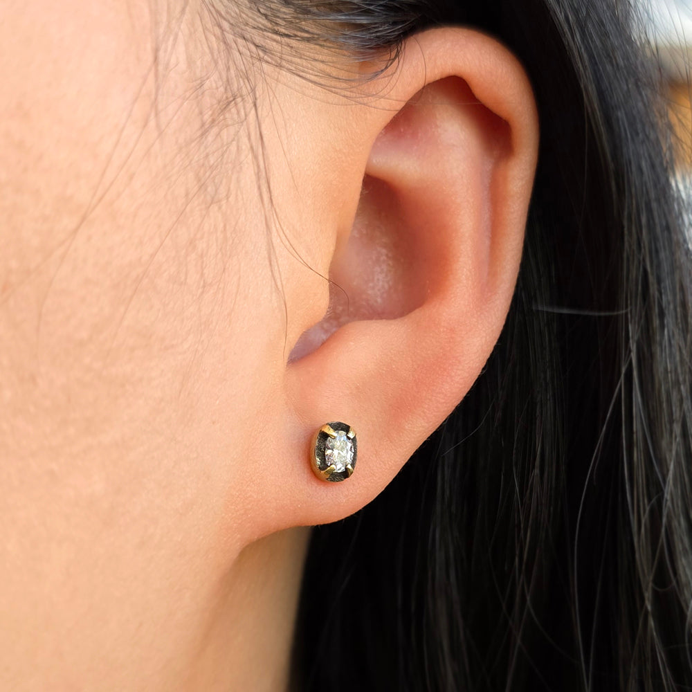Woman wearing Night Aperture oval diamond studs by Todd Pownell from Alara Jewelry