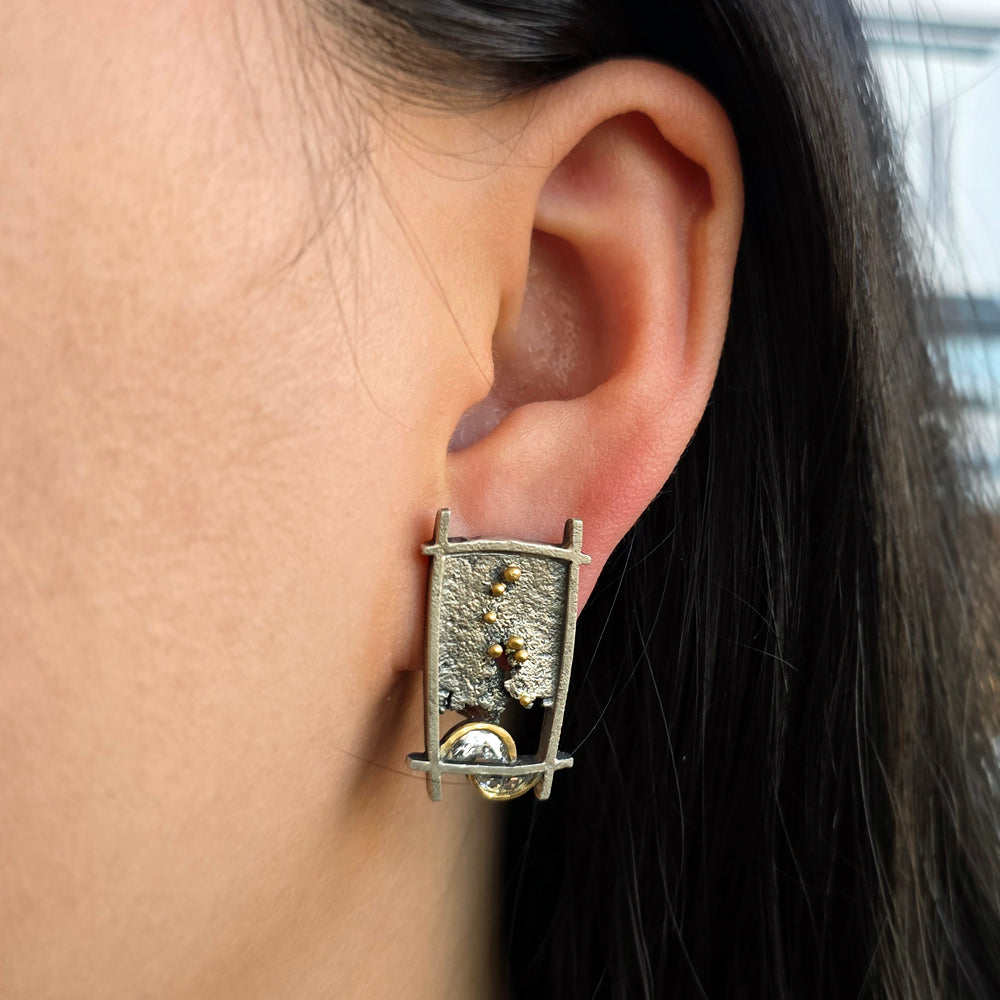 Woman wearing Shoji Lantern diamond stud earrings in oxidized silver and gold from Alara Jewelry