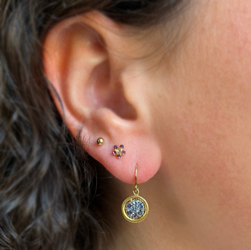 Woman wearing Mosaic Yogo sapphire earrings by Aaron Henry from Alara Jewelry