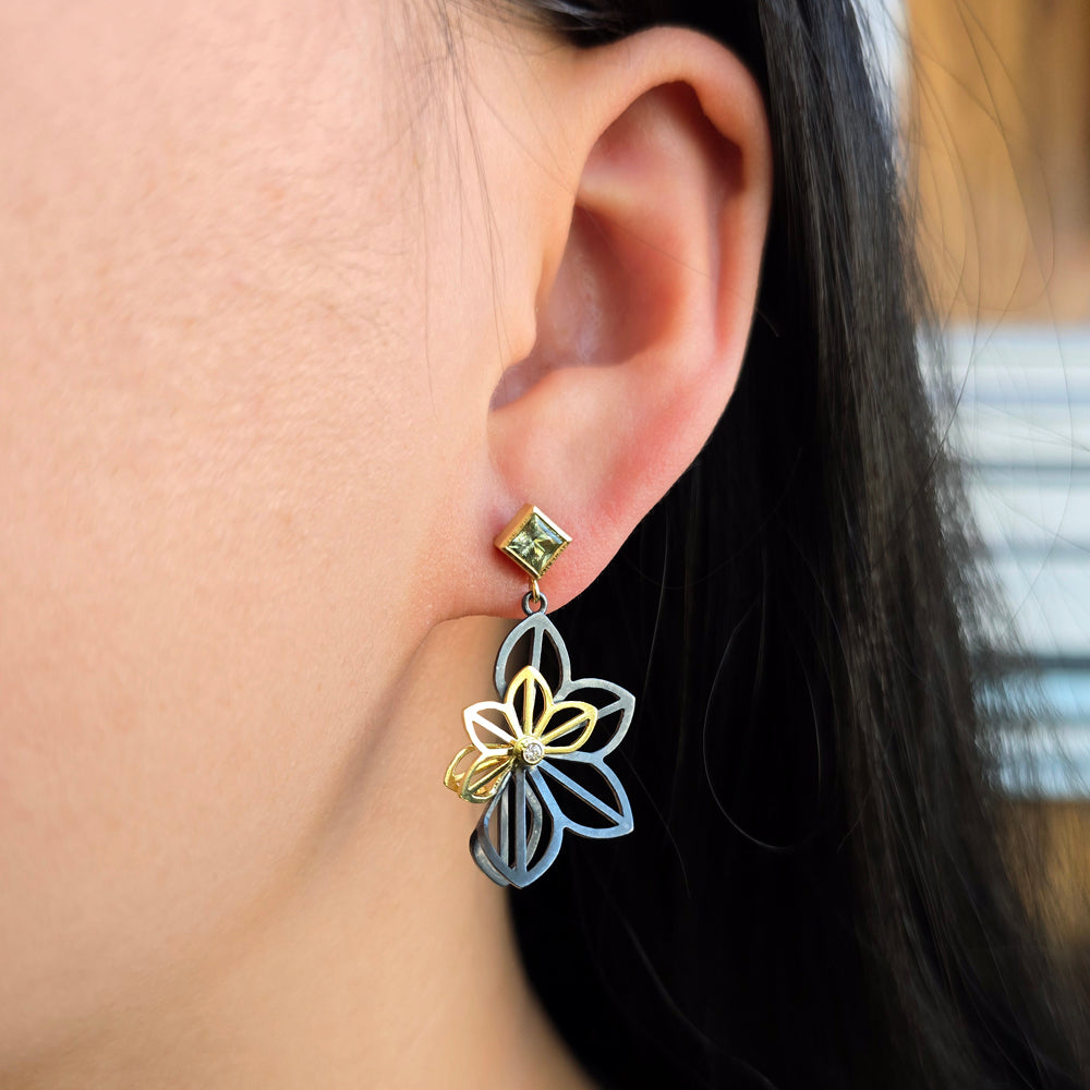 Woman wearing green Montana sapphire floral earrings by Karin Jacobson from Alara Jewelry