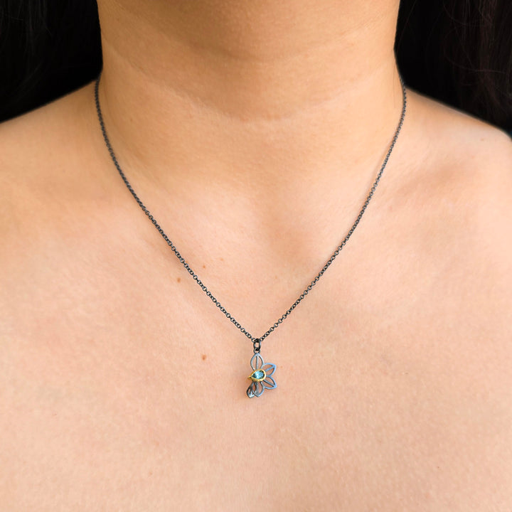 Woman wearing green Montana sapphire Anise Fold necklace by Karin Jacobson from Alara Jewelry