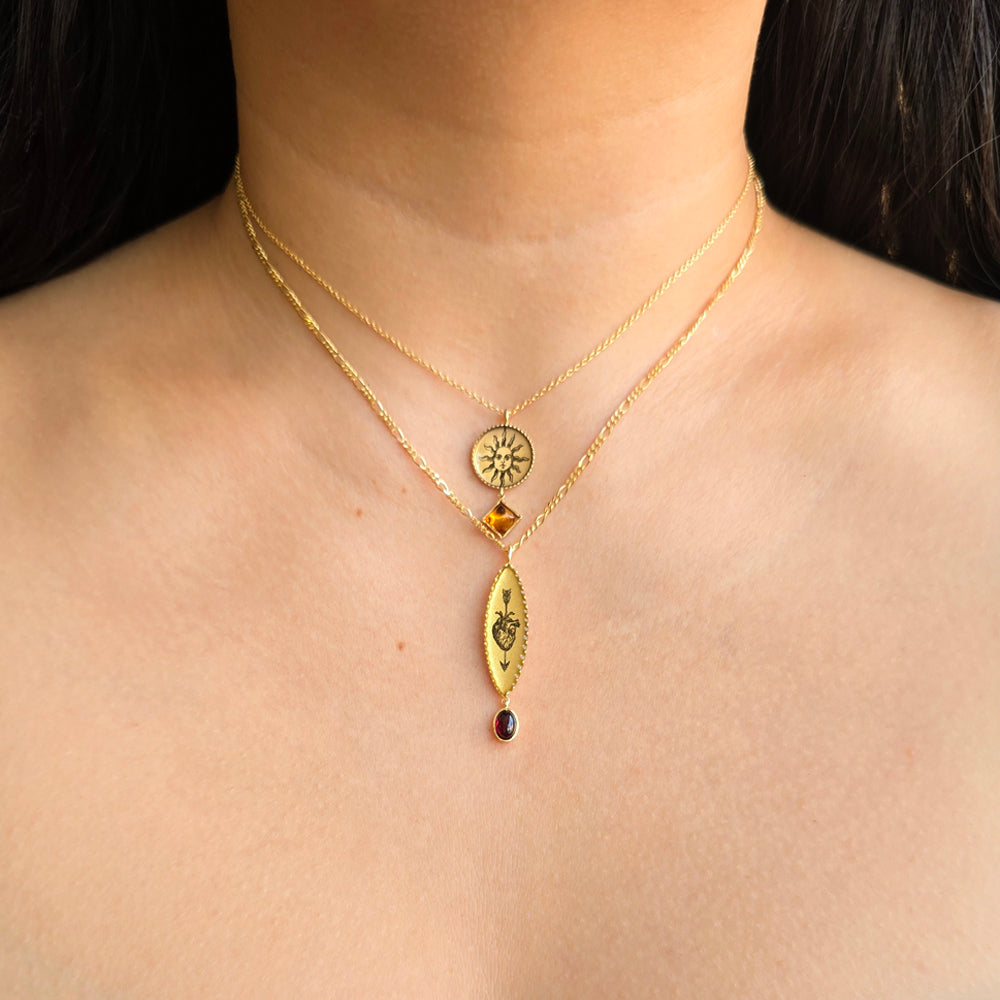 Woman wearing Bleeding Heart garnet pendant and other necklaces by Anna Bánkuti from Alara Jewelry 