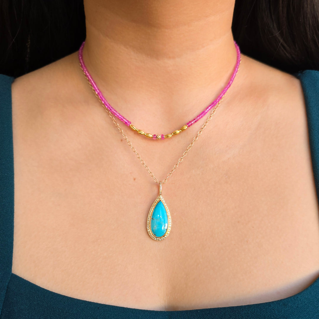 Pink sapphire strand necklace with diamond-accented center bead worn with layered look