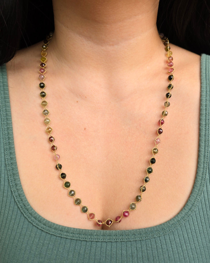 Woman wearing Amáli rainbow tourmaline necklace from Alara Jewelry