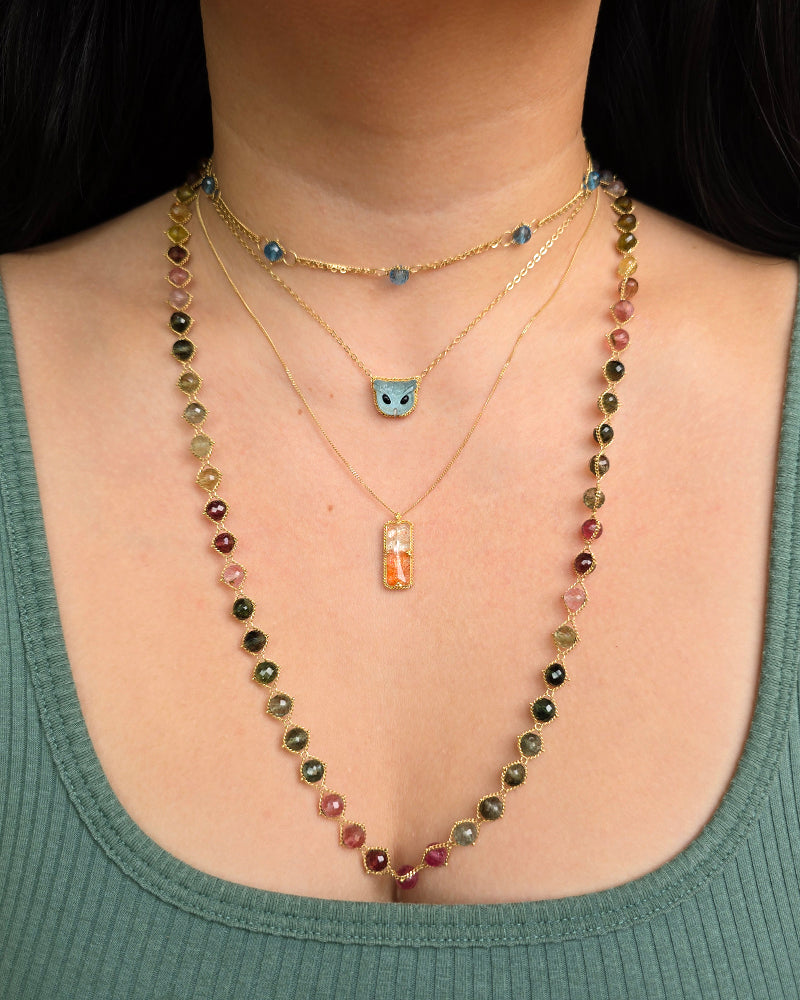 Woman wearing Amáli rainbow tourmaline necklace from Alara Jewelry