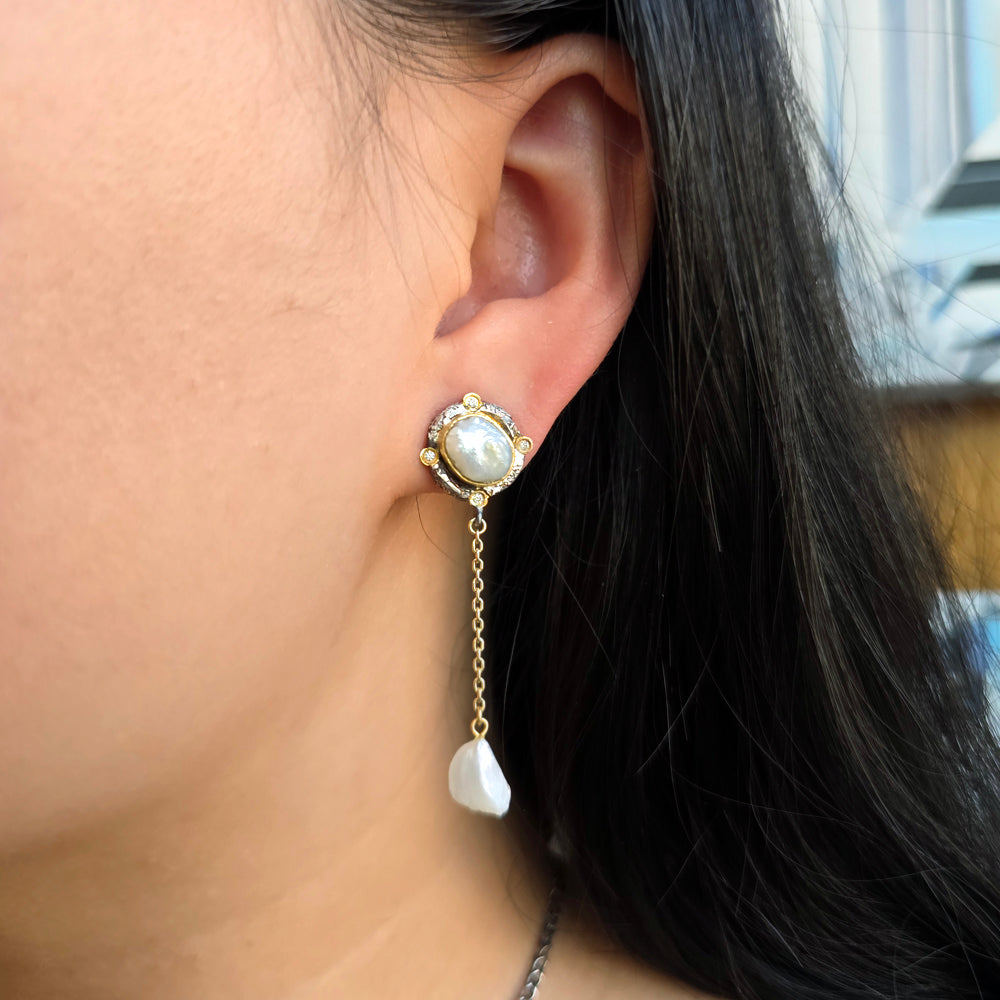 Woman wearing Mississippi River wing pearl drop earrings with gold and diamond detailing from Alara Jewelry