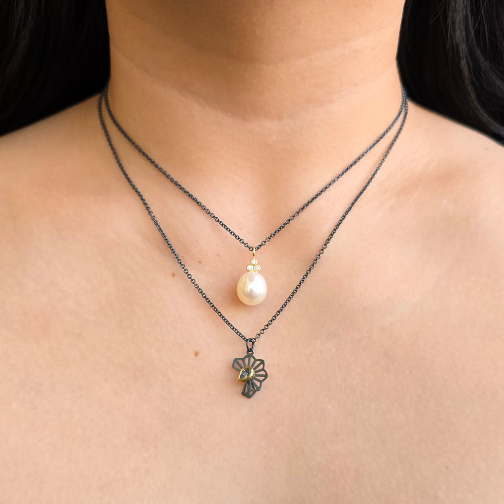 Woman wearing blue Montana sapphire Hyacinth Fold necklace from Alara Jewelry