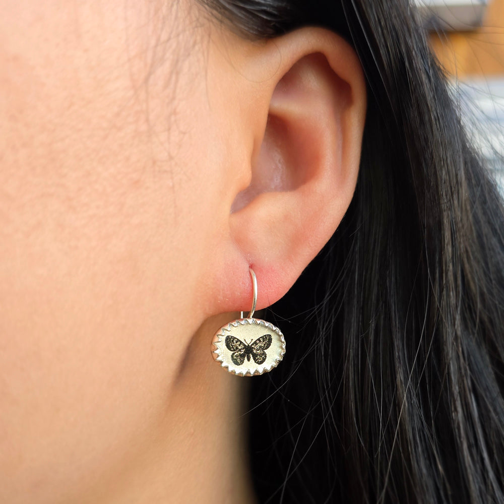 Woman wearing Pillangó butterfly earrings by Anna Bánkuti from Alara Jewelry
