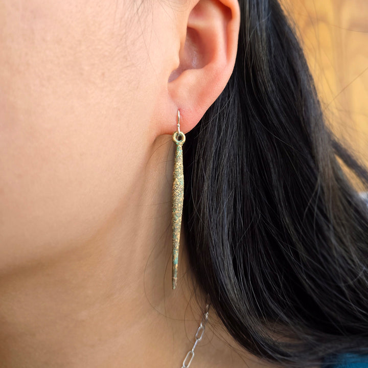 Woman wearing long bronze drop earrings with sterling silver earwires from Alara Jewelry