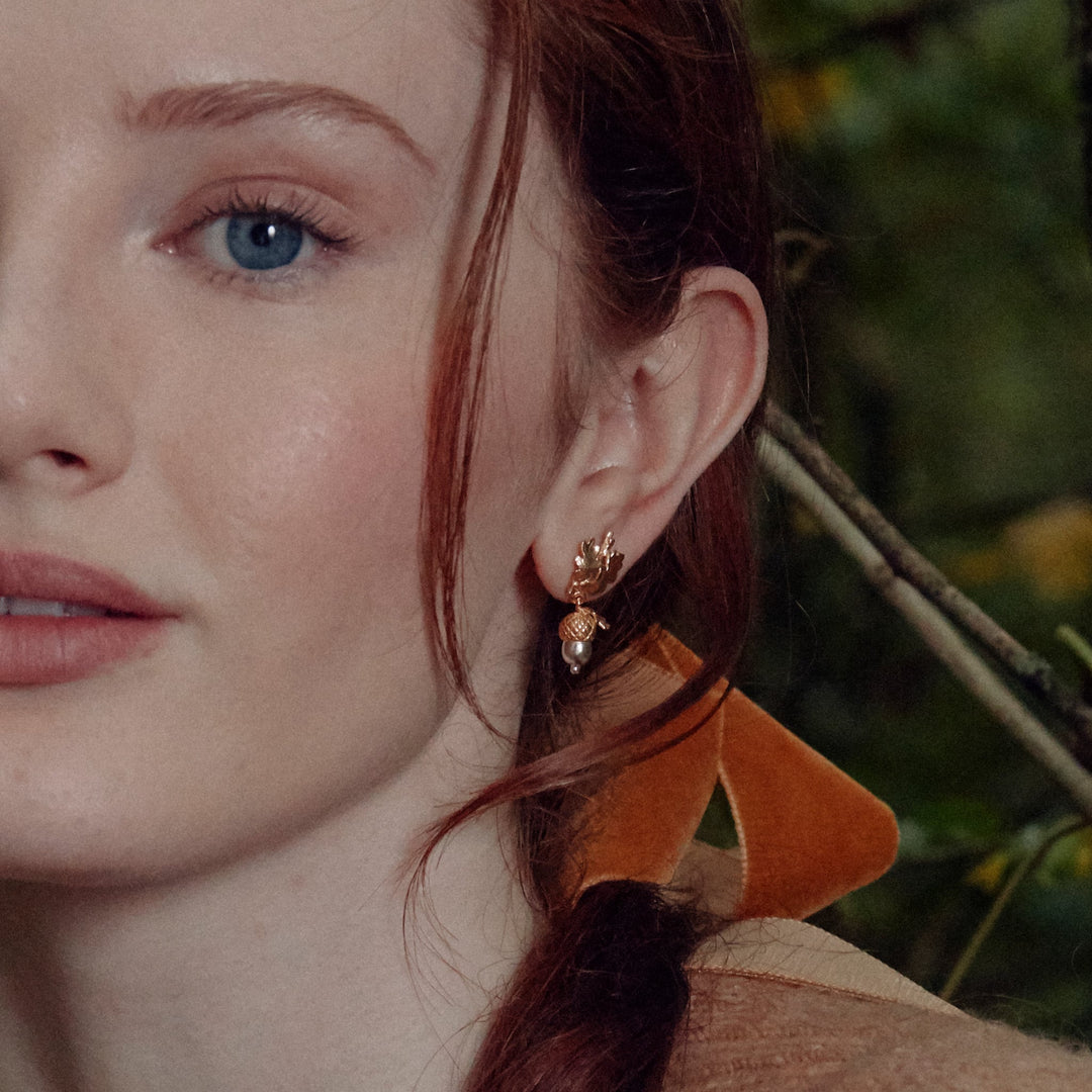Woman wearing acorn drop earrings by Alex Monroe from Alara Jewelry