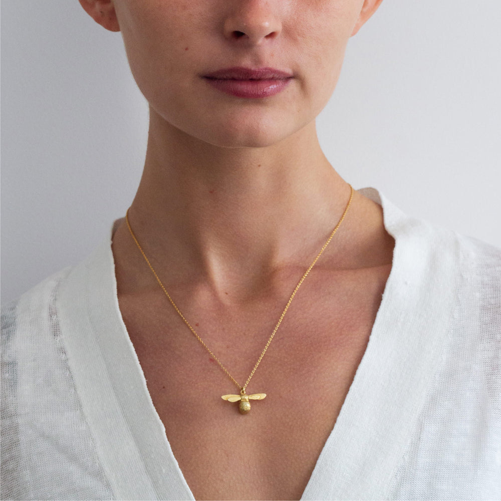 Woman wearing Baby Bee gold vermeil necklace by Alex Monroe from Alara Jewelry