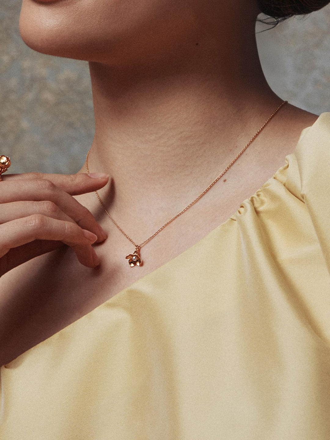 Woman wearing Cuckoo Flower pearl necklace by Alex Monroe from Alara Jewelry