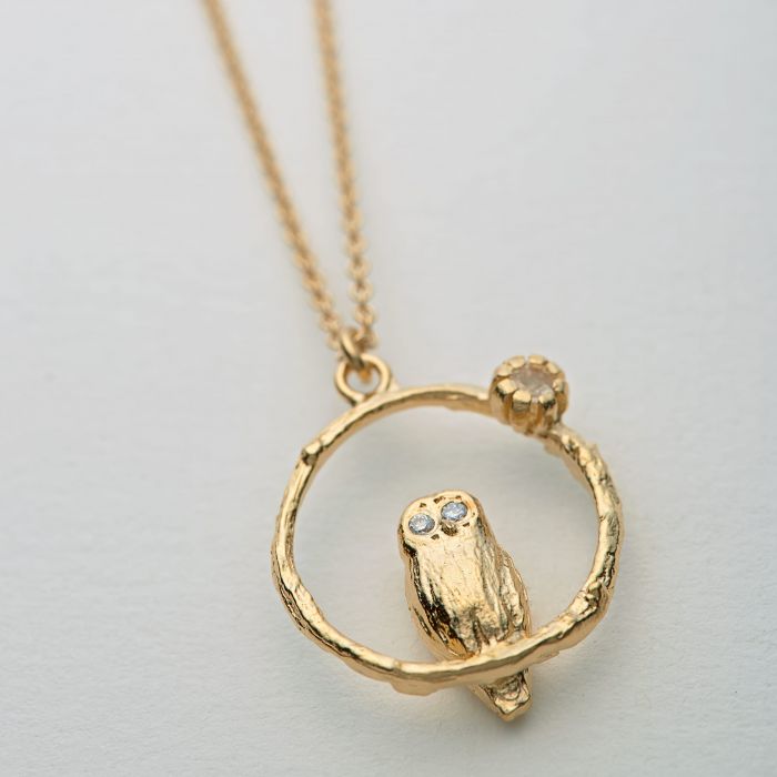 Close-up of branch-like detail and moonstone on owl pendant