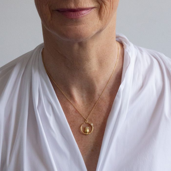 Woman wearing Peering Owl moonstone necklace by Alex Monroe from Alara Jewelry