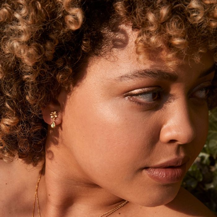 Woman wearing Small Rosette peridot earrings by Alex Monroe from Alara Jewelry
