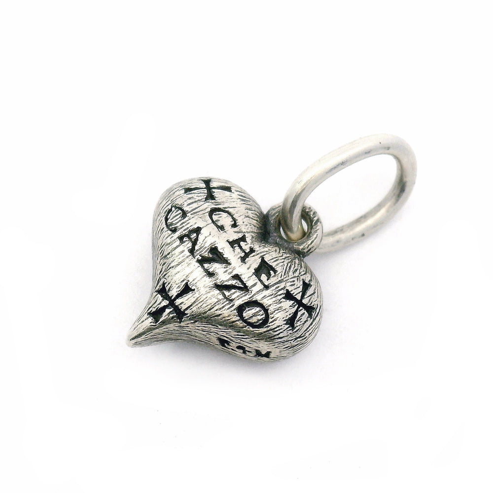 Close-up of engraved sterling silver heart charm with elongated bail