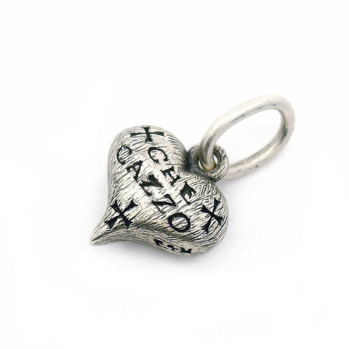 Close-up of engraved sterling silver heart charm with elongated bail