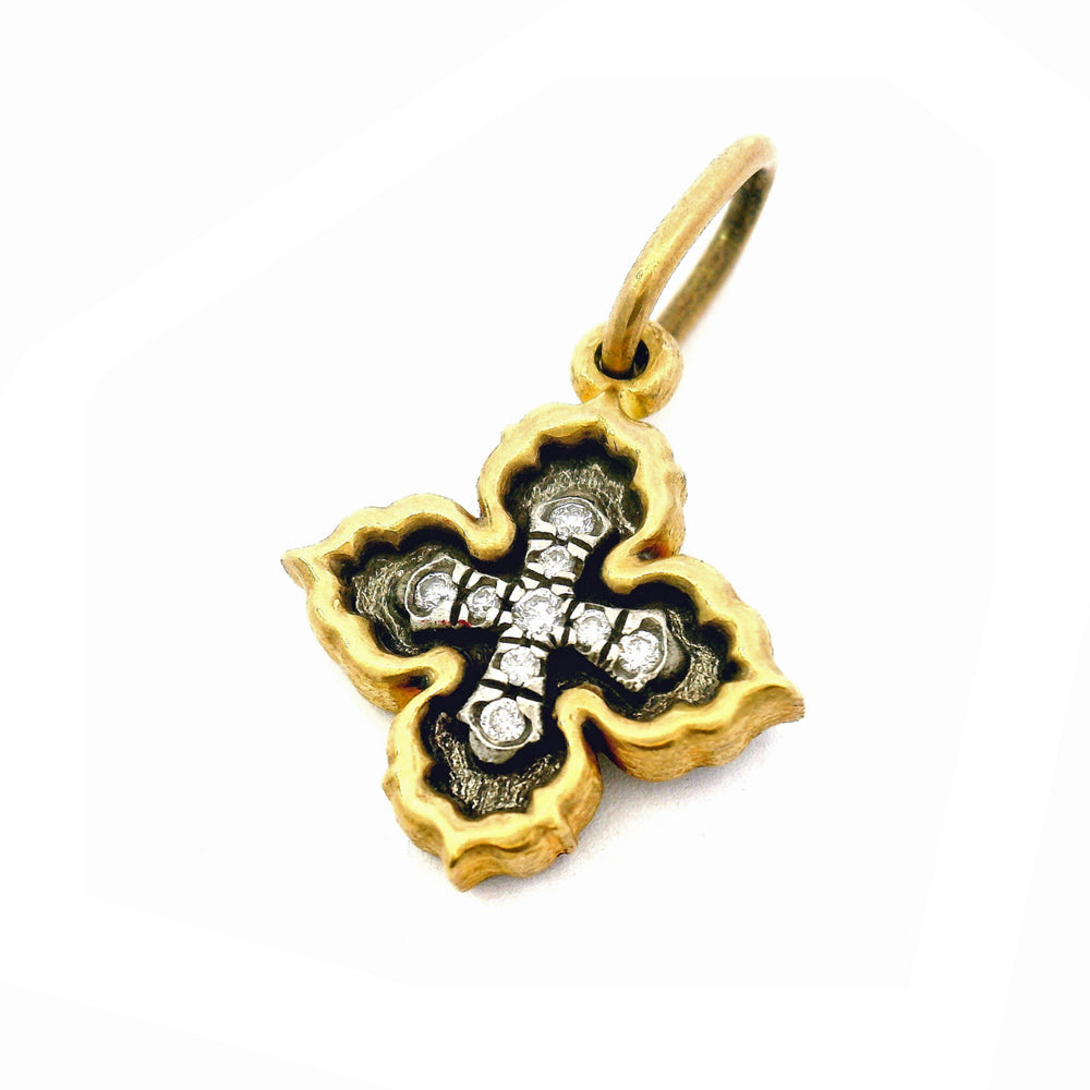 Close-up of oxidized silver and gold quatrefoil pendant with pavé diamonds