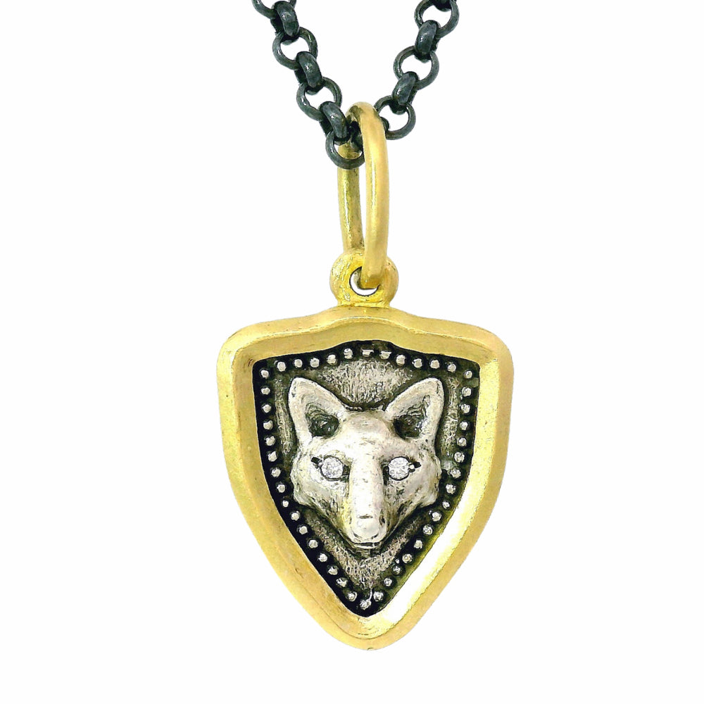 Close-up of sculptural fox and botanical charm with hand-textured silver background