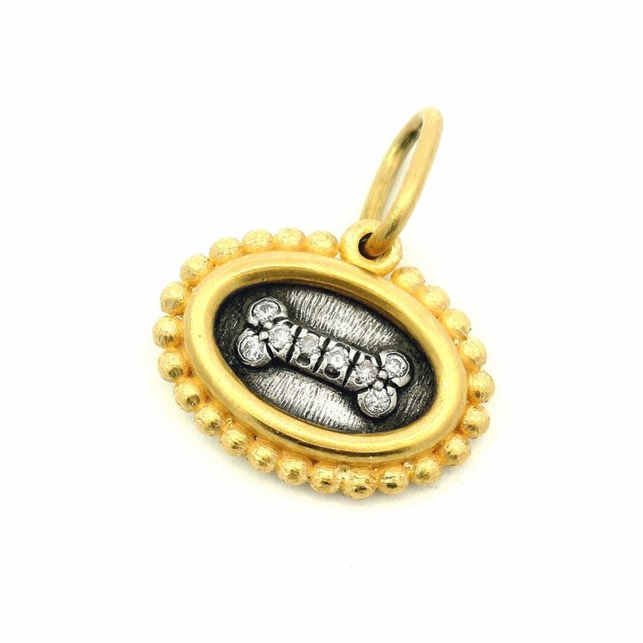 Reversible dog bone charm pendant by Erica Molinari in gold and silver