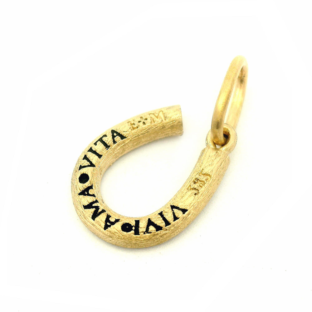 Reversible horseshoe pendant with milgrain detail and hidden Italian inscription