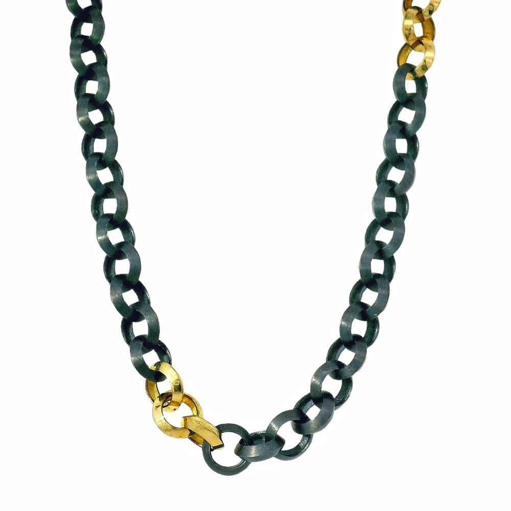 Close-up of gold station detail on oxidized silver link necklace