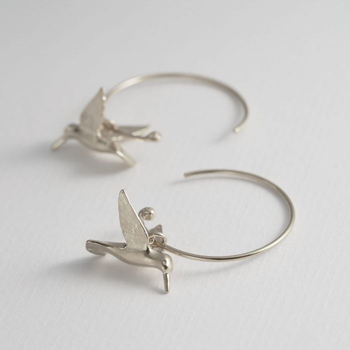 Close-up of hand-detailed hummingbird wings on silver hoop earring