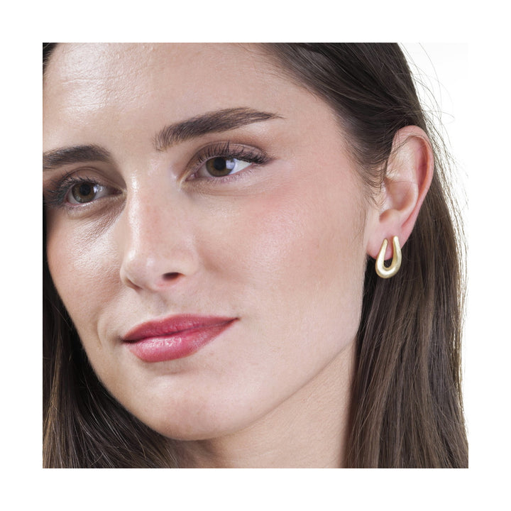 Woman wearing Cotton Collection satin gold stud earrings by Jorge Revilla from Alara Jewelry
