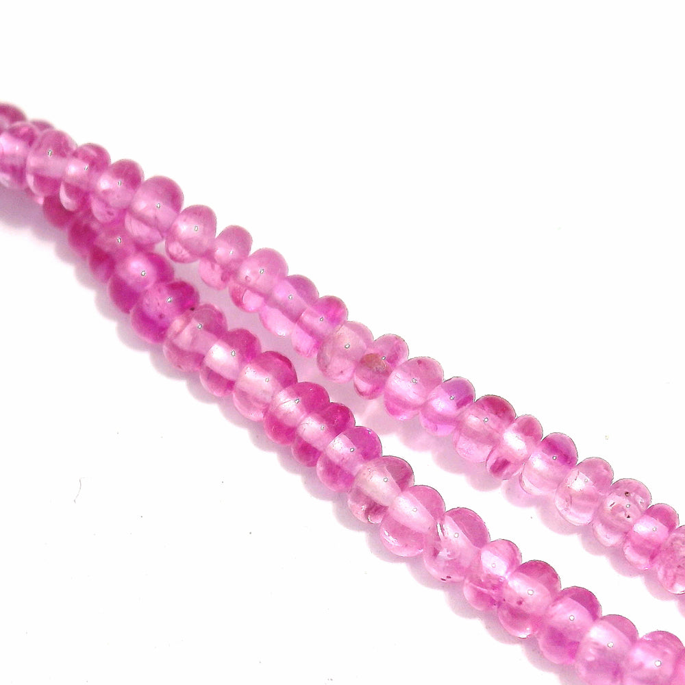 Close-up of faceted pink sapphire beads and gold link detail