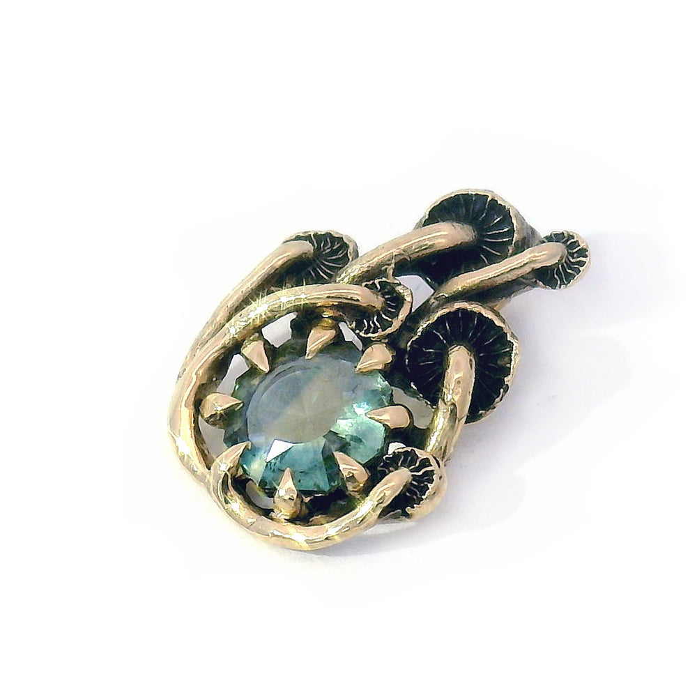 Close-up of light green-blue Montana sapphire and mushroom setting laying down