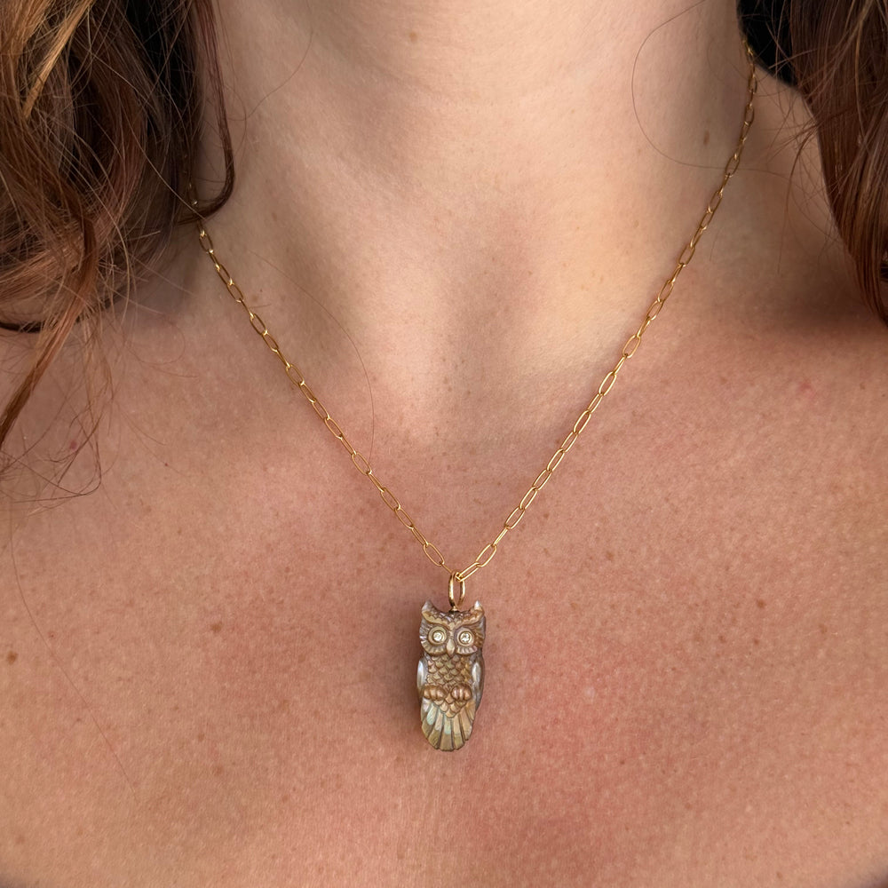 Woman wearing hand-carved owl pendant by Maura Green from Alara Jewelry