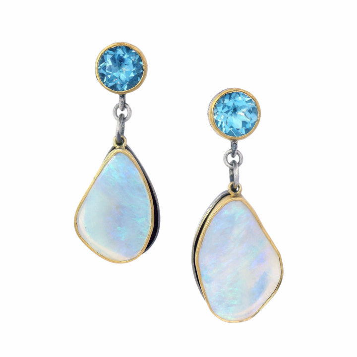 A pair of drop earrings featuring round light blue gemstones at the top and teardrop-shaped iridescent white opal-like pendants in gold and silver settings, shown on a plain white background.