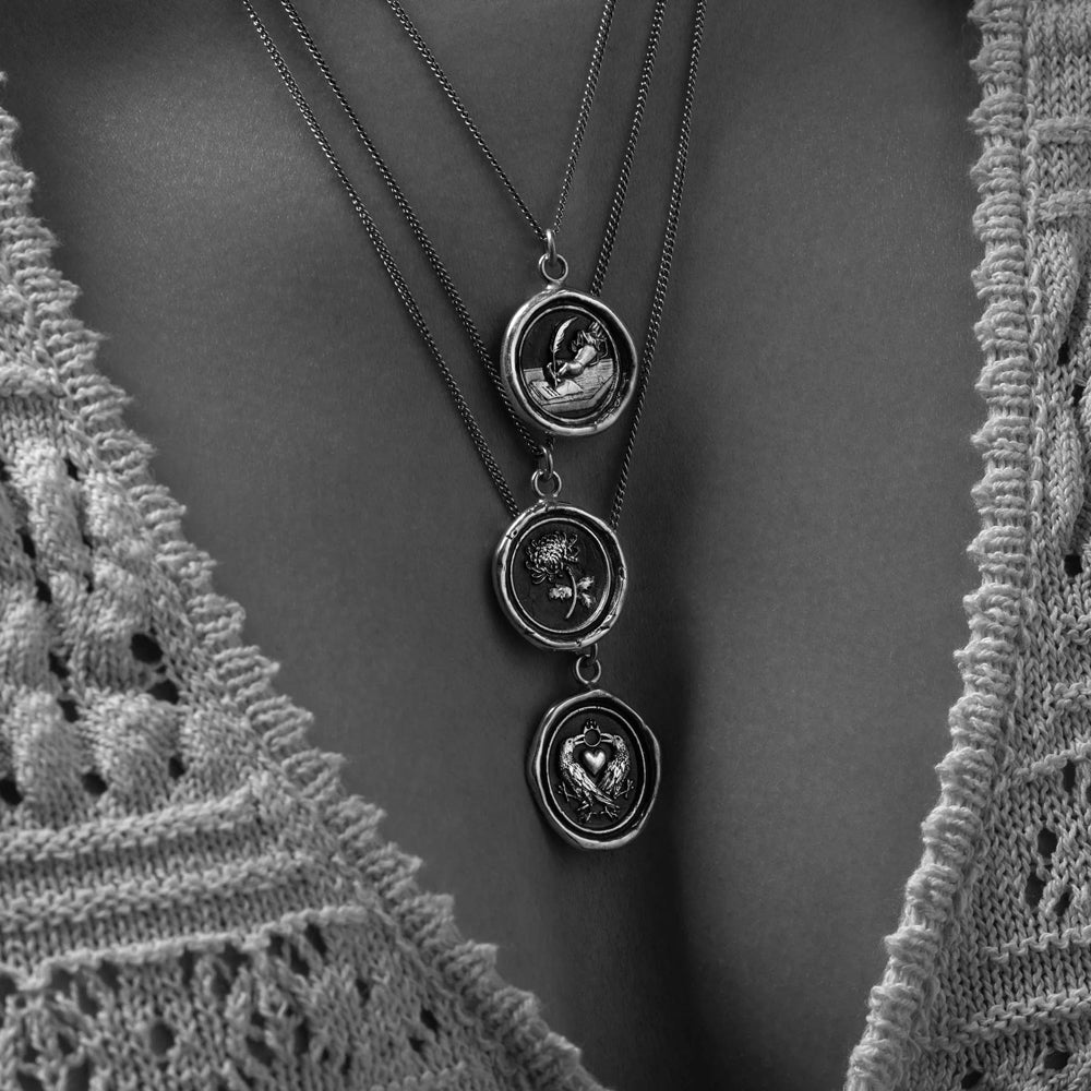 Woman wearing chrysanthemum talisman necklace by Pyrrha from Alara Jewelry