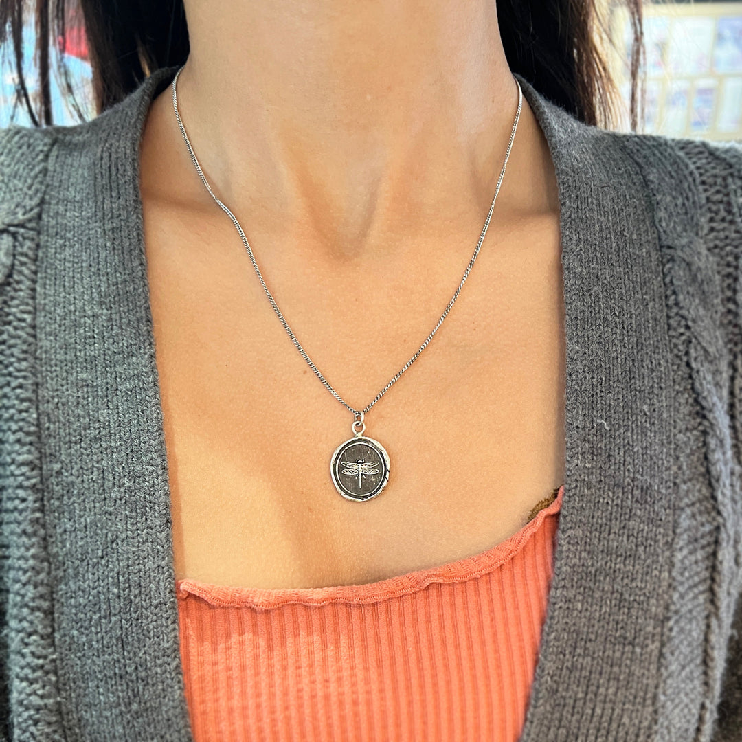 Woman wearing Dragonfly talisman necklace by Pyrrha from Alara Jewelry