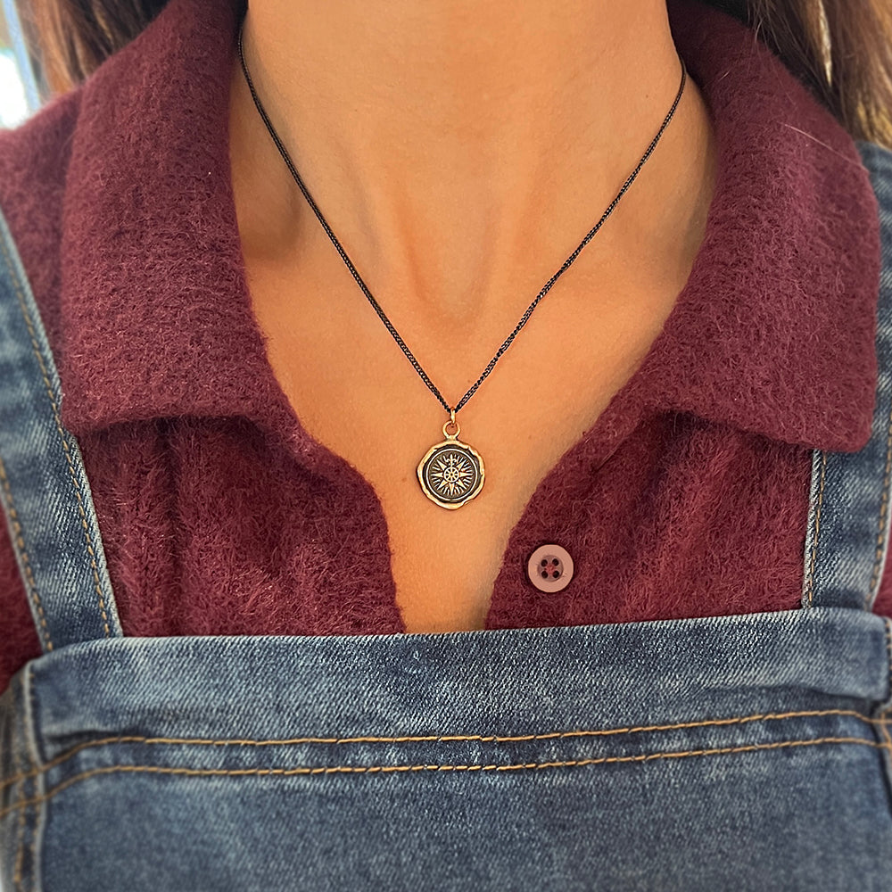 Woman wearing Direction compass talisman necklace by Pyrrha from Alara Jewelry