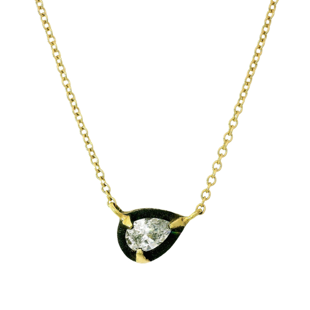 Close-up of pear-shaped diamond suspended in oxidized white gold halo