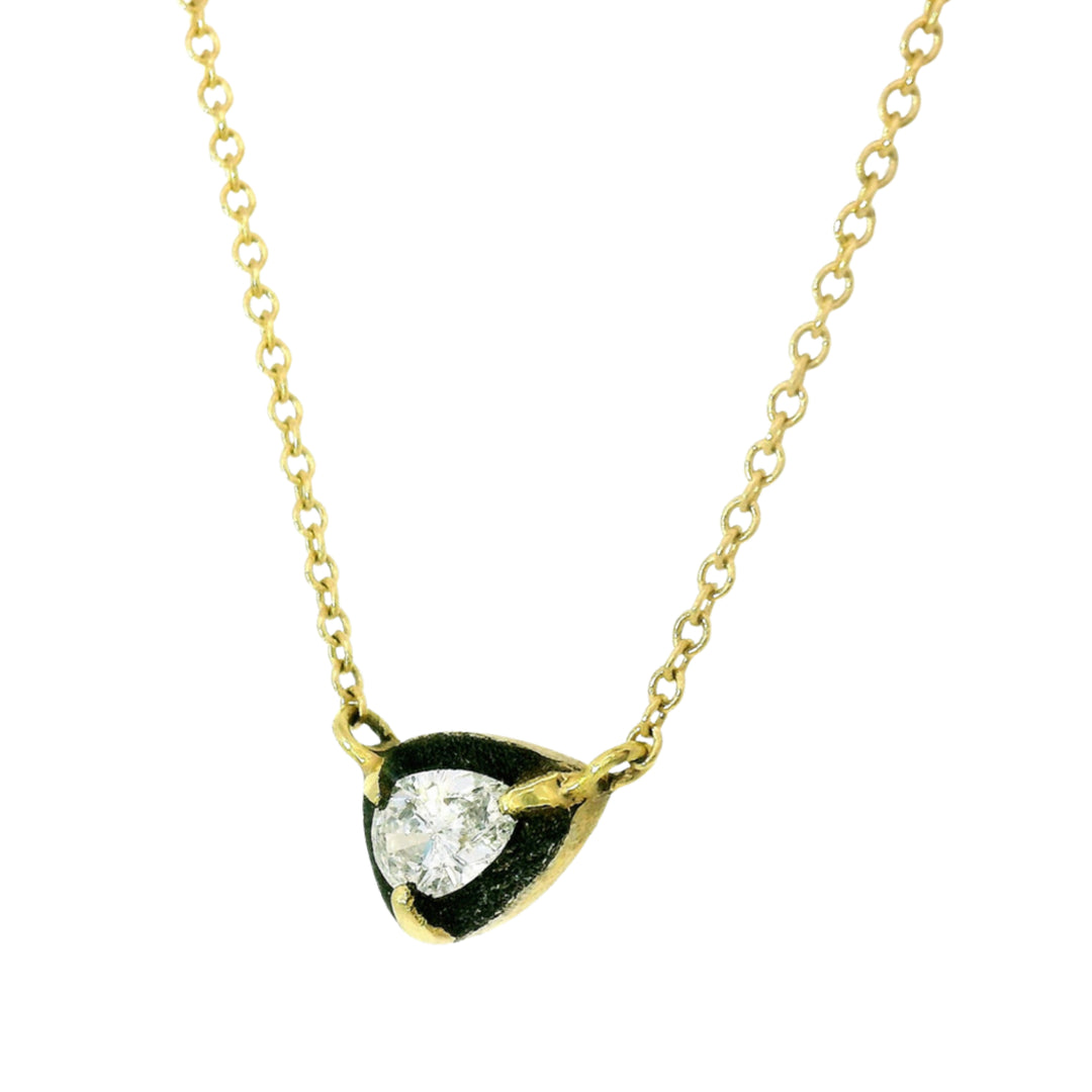 Close-up of side of pear-shaped diamond suspended in oxidized white gold halo