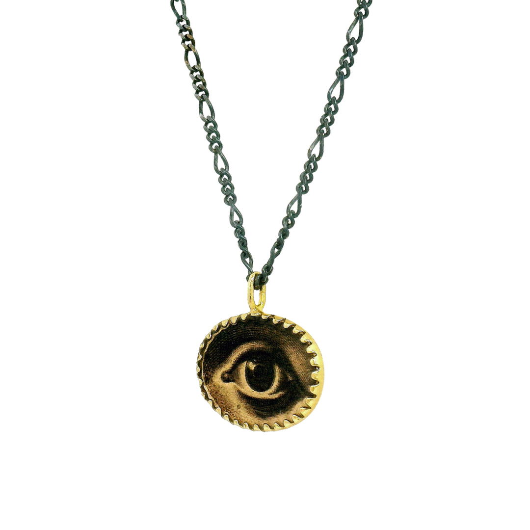 Close-up of etched lover's eye illustration on gold vermeil pendant