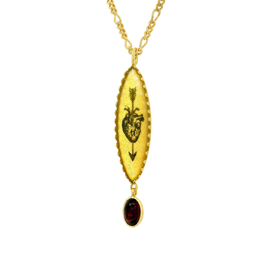 Close-up of etched heart and arrow motif with red garnet accent