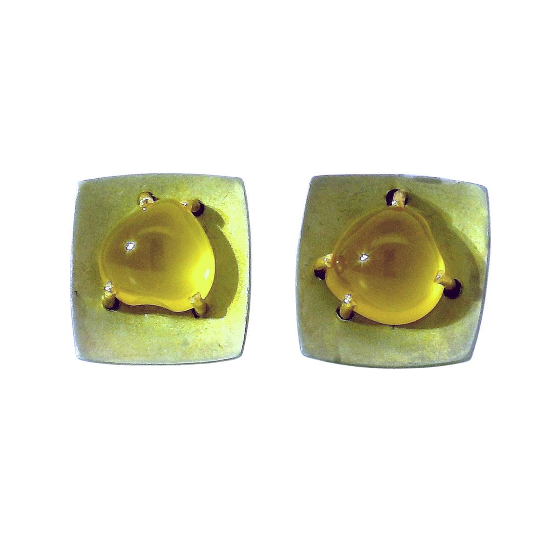Close-up of golden yellow beryl cabochon in squared metal setting